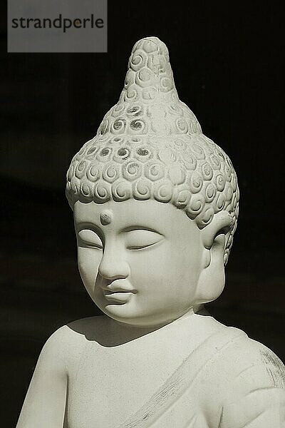 Dekorative buddha-statue im direkten sonnenlicht - buddhismus meditation erleuchtung glaube und spiritualität konzept