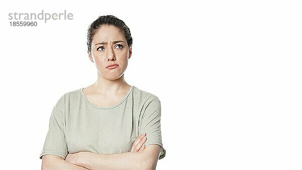 Unglückliche nachdenkliche junge Frau mit besorgtem Gesichtsausdruck  die über ein Problem nachdenkt - vor weißem Hintergrund mit Kopierraum