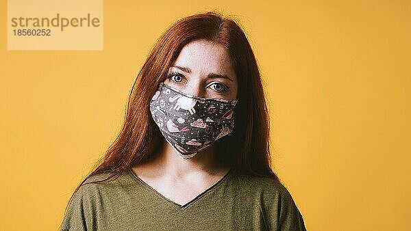 Junge Frau trägt eine selbstgemachte Gesichtsmaske aus Stoff oder eine Gemeinschaftsmaske - Covid-19-Coronavirus-Pandemie-Hygiene-Konzept