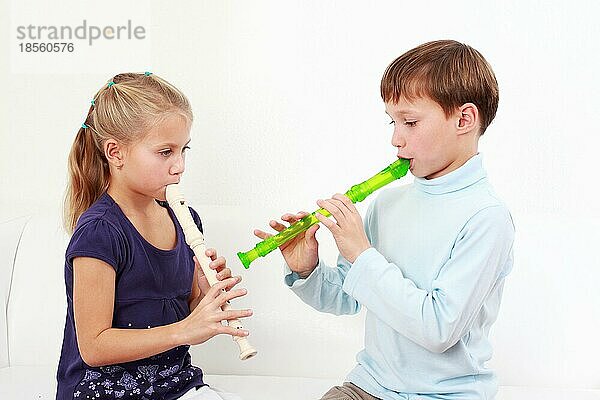 Niedliche Kinder spielen zusammen Flöte
