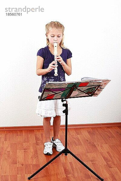 Nettes Mädchen spielt Flöte mit Musiknoten