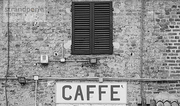 Toskana  Italien. Altes Caffè Schild unter einem traditionellen italienischen Fenster