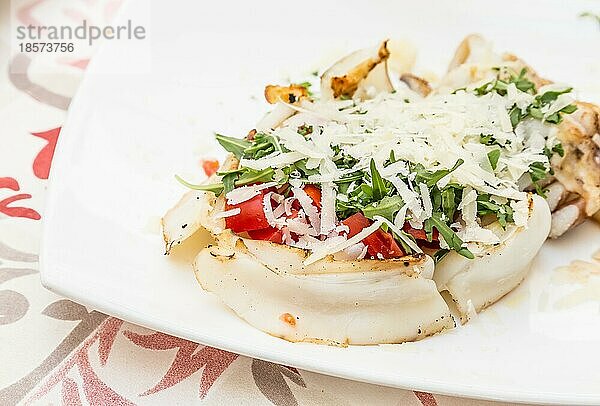 Italienisches Restaurant in Gallipoli  Region Apulien (Süditalien) . Traditioneller Tintenfisch mit frischem Salat  Tomaten und echtem Parmigiano Käse. Tageslicht