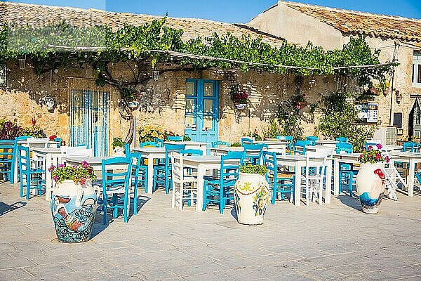 Tische und Stühle in einem traditionellen italienischen Restaurant in Marzamemi Sizilien an einem sonnigen Tag