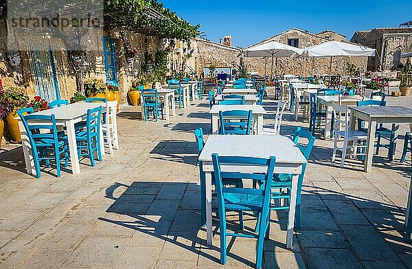 Tische und Stühle in einem traditionellen italienischen Restaurant in Marzamemi Sizilien an einem sonnigen Tag