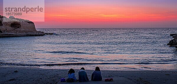 Drei Frauen warten auf den Sonnenaufgang vor dem Meer (Region Apulien) (Süditalien) . Konzept von Freundschaft  Reisen und Abenteuer