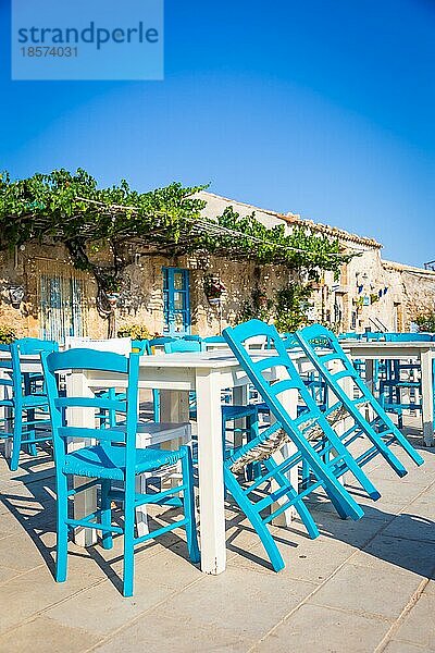 Tische und Stühle in einem traditionellen italienischen Restaurant in Marzamemi Sizilien an einem sonnigen Tag