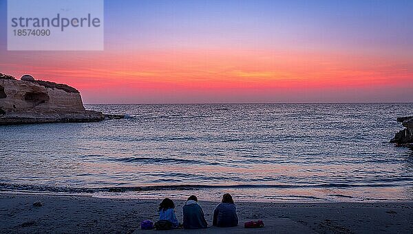Drei Frauen warten auf den Sonnenaufgang vor dem Meer (Region Apulien) (Süditalien) . Konzept von Freundschaft  Reisen und Abenteuer