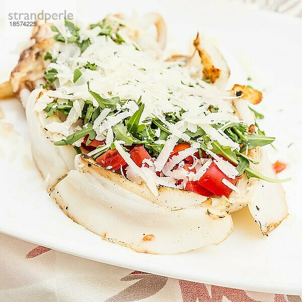 Italienisches Restaurant in Gallipoli  Region Apulien (Süditalien) . Traditioneller Tintenfisch mit frischem Salat  Tomaten und echtem Parmigiano Käse. Tageslicht