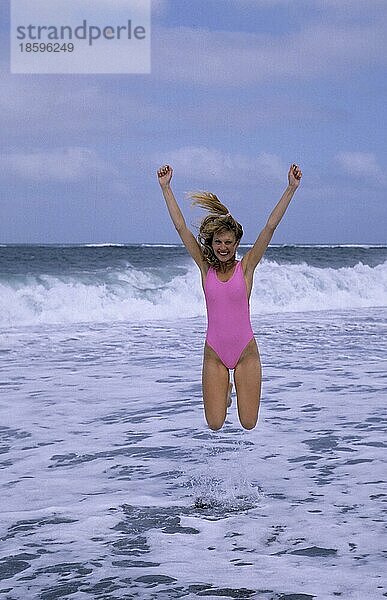 Junge Frau am Strand  Action  Luftsprung