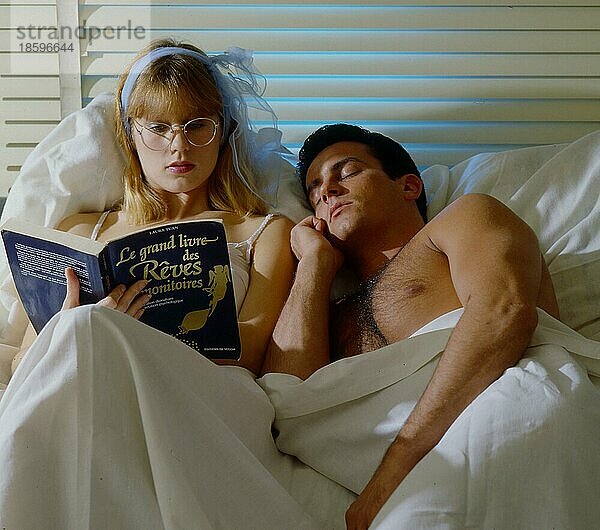 Mann und Frau im Bett Frau liest Zeitung  Mann schläft schon