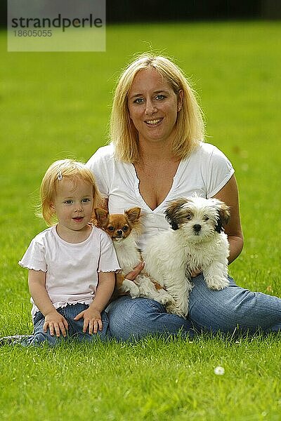 Frau und Tochter mit Chihuahua und Mischlingshund  Welpe