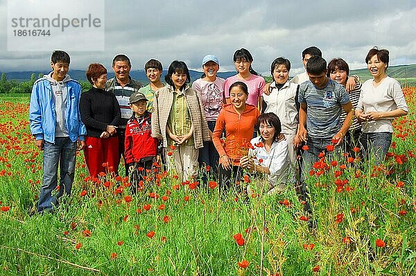 Gruppe junger Leute  in Klatschmohnfeld  Kirgistan  Kirgisistan  Kirgisien  Asien