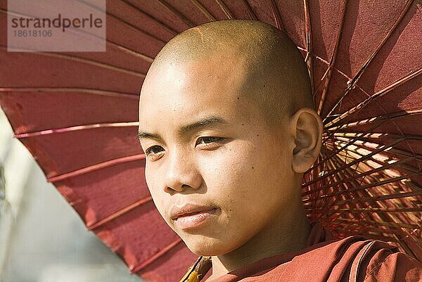 Junger buddhistischer Mönch mit Sonnenschirm  Mingun  Burma  Myanmar  Asien