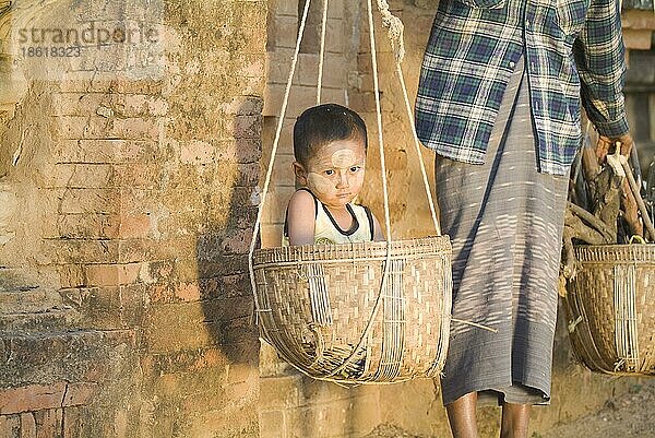 Burmesin trägt Kind und Holz im Korb über Schulter  Bagan  Burma  Pagan  Myanmar  Asien