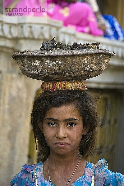 Indisches Mädchen trägt Becken mit Kuhmist auf dem Kopf  Jaisalmer  Rajasthan  Indien  Asien
