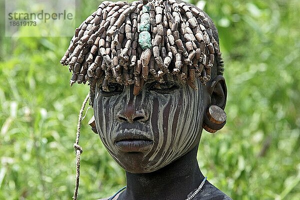 Nahaufnahme eines Kindes des Mursi-Stammes mit traditionellem Kopfschmuck  Omo-Tal  Äthiopien  Ostafrika  Afrika