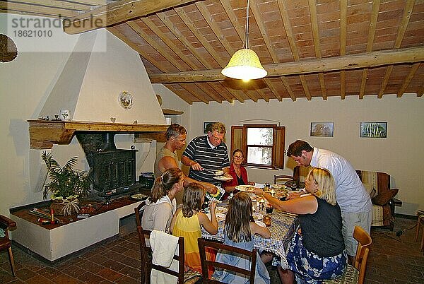 Familie am Esstisch in Ferienwohnung  Castelfalfi  Toskana  Italien  Europa