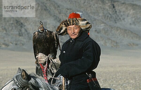 Kasachen-Mann mit Steinadler  weiblich mit Lederkaeppchen  bei Steinadler-Fest  Provinz Bayan Olgiy  Mongolei  Kosake  Kosaken  Steinadler-Jäger  Asien