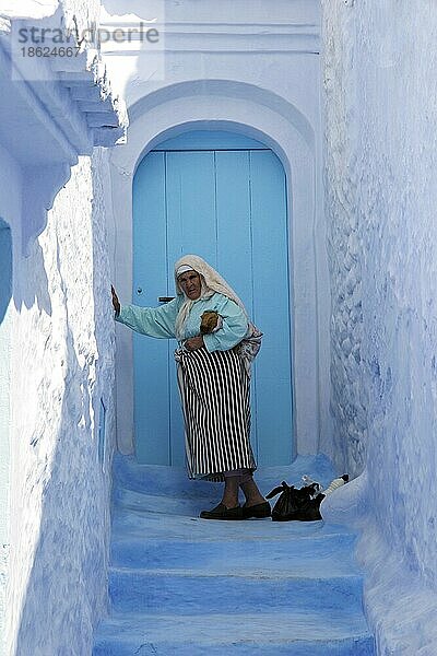 Alte Frau betritt Haus in blauer Medina in Chefchaouen  Chaouen  Marokko  Nordafrika  Afrika