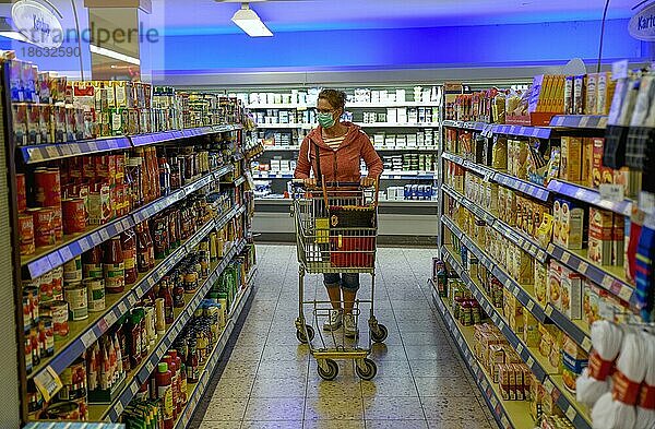 Frau mit Mundschutz beim Einkaufen in einem Supermarkt  Corona-Krise  Pandemie  Baden-Württemberg  Deutschland  Europa