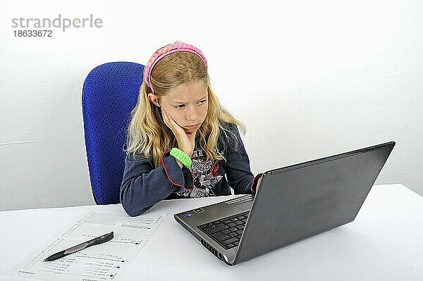 Mädchen mit Laptop macht Hausaufgaben  Schulaufgaben  lernen  lernt  üben  übt  skeptisch