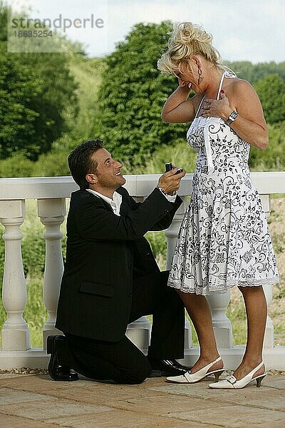 Mann macht Frau Heiratsantrag  auf Knien  Augenkontakt  kniet