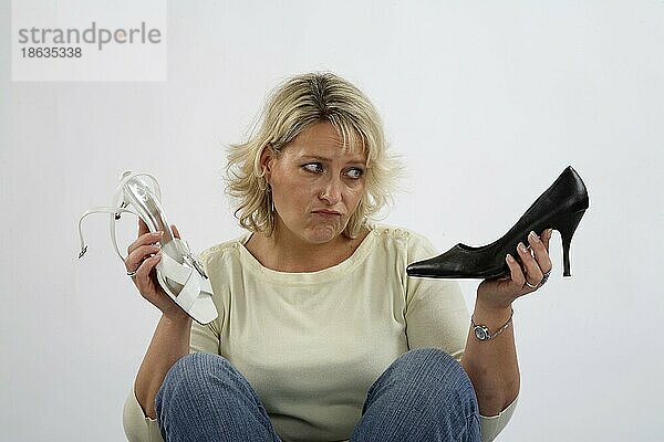 Unentschlossene Frau bei der Schuhauswahl  unentschlossen  unschlüssig