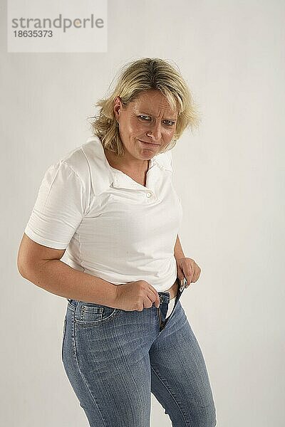Frau bekommt enge Jeans nicht zu  zu eng  zu klein  zu enge Hose  ärgerlich