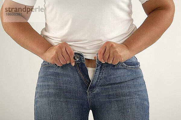 Frau versucht Jeans zuzuknoepfen  zu eng  zu klein  zu enge Hose