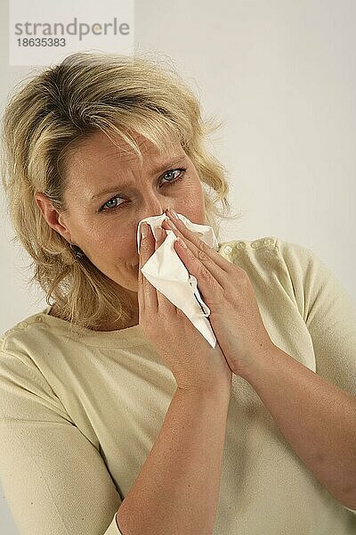 Frau putzt ihre Nase  Schnupfen  sich schneuzen