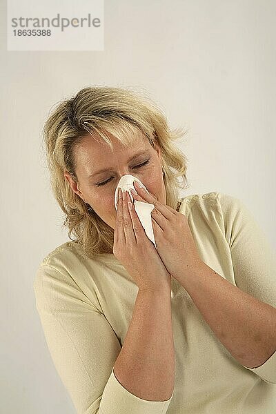 Frau putzt ihre Nase  Schnupfen  sich schneuzen