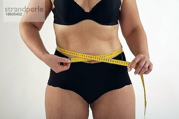 Frau mißt Taille mit Maßband  Diät  Hueftumfang
