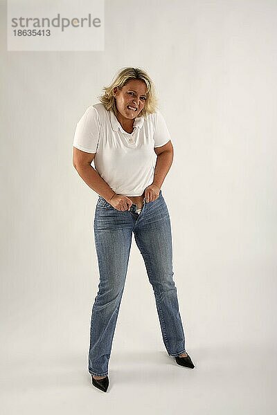 Frau versucht Jeans zuzuknoepfen  zu eng  zu klein  zu enge Hose  Freisteller