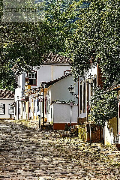 Abhang mit Steinpflaster und alten bunten Häusern im Kolonialstil in der Stadt Tiradentes in Minas Gerais  Brasilien  Südamerika
