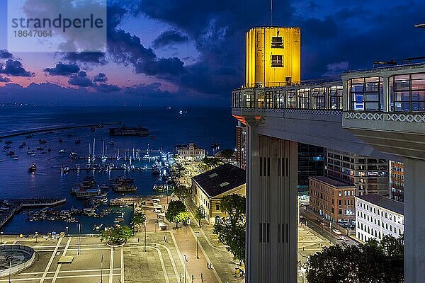 Fassade des berühmten Lacerda Aufzugs bei Nacht beleuchtet mit Stadt und Booten im Hintergrund in Salvador  Bahia  Brasilien  Südamerika