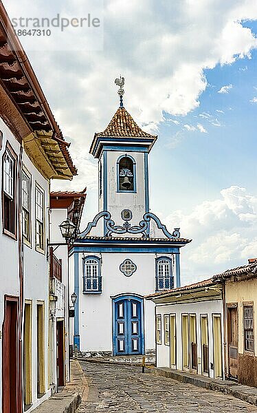 Straße mit Kopfsteinpflaster und Häusern im Kolonialstil mit einer historischen Kirche im Hintergrund in der berühmten Stadt Diamantina in Minas Gerais  Brasilien  Südamerika