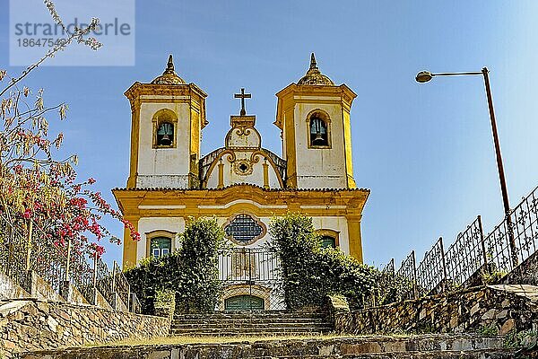 Blick von unten auf eine alte Treppe und eine historische Kirche aus dem 18. Jahrhundert im Kolonialstil auf einem Hügel in der Stadt Ouro Preto in Minas Gerais  Brasilien  mit den Bergen im Hintergrund  Ouro Preto  Minas Gerais  Brasilien  Südamerika