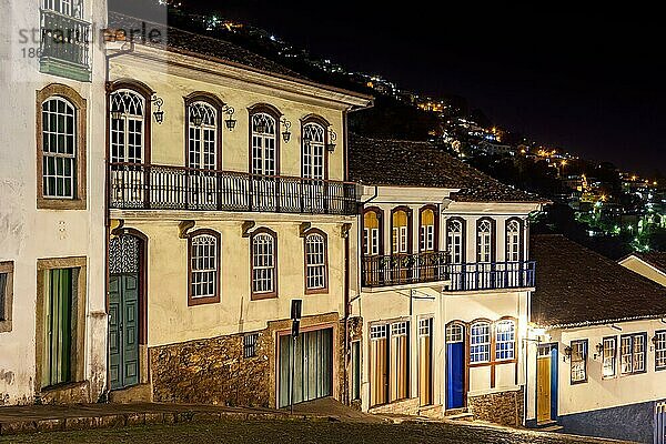 Fassaden von Häusern im Kolonialstil in einer alten Kopfsteinpflasterstraße in der Stadt Ouro Preto bei Nacht beleuchtet  Ouro Preto  Minas Gerais  Brasilien  Südamerika