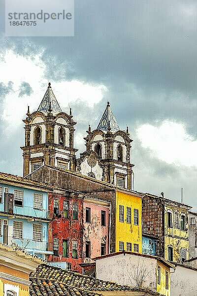 Historischer barocker Kirchturm hinter den Fassaden alter Häuser im Kolonialstil in Pelourinho in der Stadt Salvador  Bahia  Brasilien  Südamerika