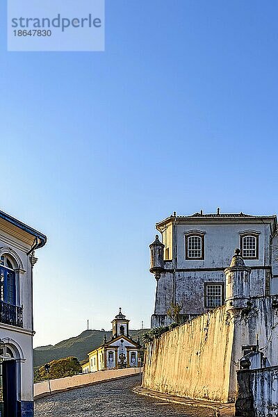 Eingangsstraße zur Stadt Ouro Preto mit Kopfsteinpflaster  ihren Kirchen und historischen Gebäuden aus der Zeit des Kaiserreichs in Brasilien  Brasilien  Südamerika