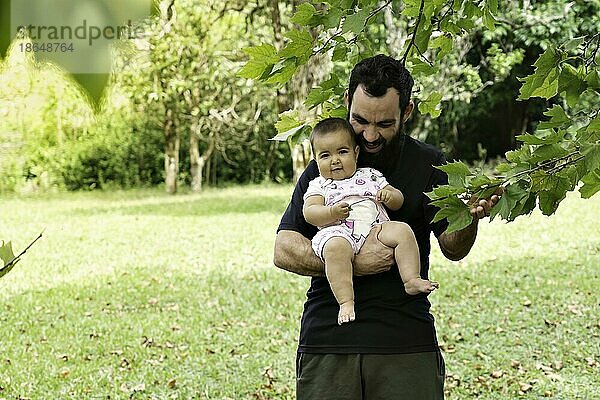 Vater hält kleines Mädchen umgeben von Natur. Vatertag Konzept