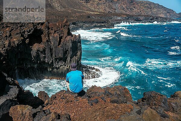 Ein junger Mann auf dem Vulkanpfad in der Stadt Tamaduste an der Küste der Insel El Hierro  Kanarische Inseln  Spanien. vertikales Foto