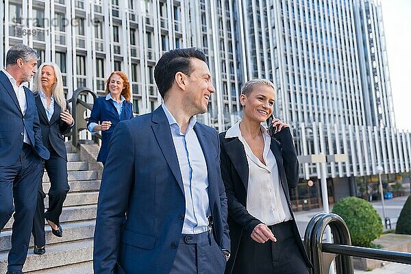 Leitende Angestellte tauschen Ideen aus  während sie im Geschäftsviertel die Treppe hinuntergehen