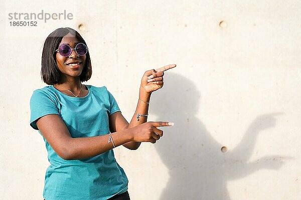 Die Schönheit in der Einfachheit finden: Junge afroamerikanische Touristin in grünem TShirt und Sonnenbrille