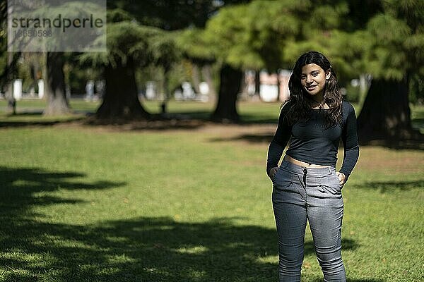 Porträt eines Mädchens im Teenageralter  das in einem Park posiert. Modell  das in einem Park eine Pose einnimmt