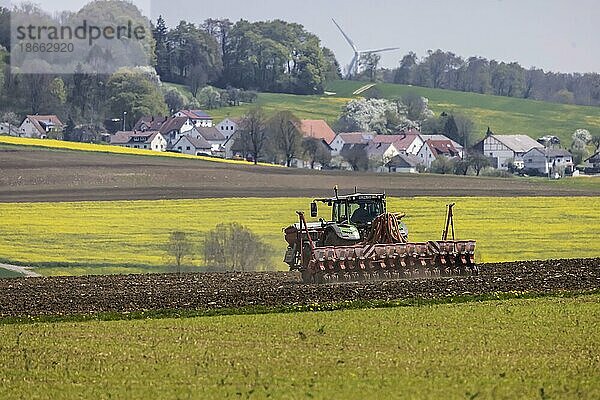 Landwirt mit Traktor bearbeitet sein Feld im Frühjahr  Stötten  Geislingen an der Steige  Baden-Württemberg  Deutschland  Europa