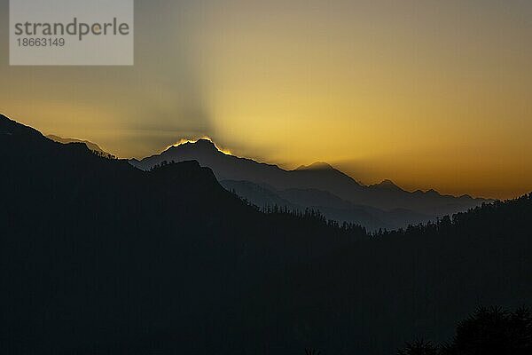 Tagesanbruch am Poon Hill. Blick in Richtung Osten  kurz vor Sonnenaufgang. Unter den Silhouetten einiger Himalaya Gipfel und Hügel befinden sich der Himalchuli  einer der höchsten Siebentausender  und der Baudha Gipfel. Der Poon Hill  ein fantastischer Aussichtspunkt  ist der Höhepunkt der relativ kurzen und einfachen Wanderung im Annapurna Schutzgebiet und zieht zahlreiche Wanderer an. Ghorepani  Annapurna Himal. Bezirk Myagdi  Provinz Gandaki  Nepal  Asien