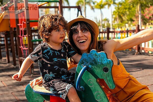 Mutter hat Spaß mit ihrem Sohn auf einem Spielplatz im Sommerurlaub