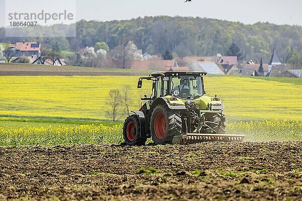 Landwirt mit Traktor bearbeitet sein Feld im Frühjahr  Stötten  Geislingen an der Steige  Baden-Württemberg  Deutschland  Europa